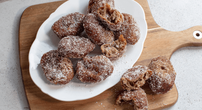 Delicious traditional Cape Malay Koesisters served on a plate, sprinkled with coconut.